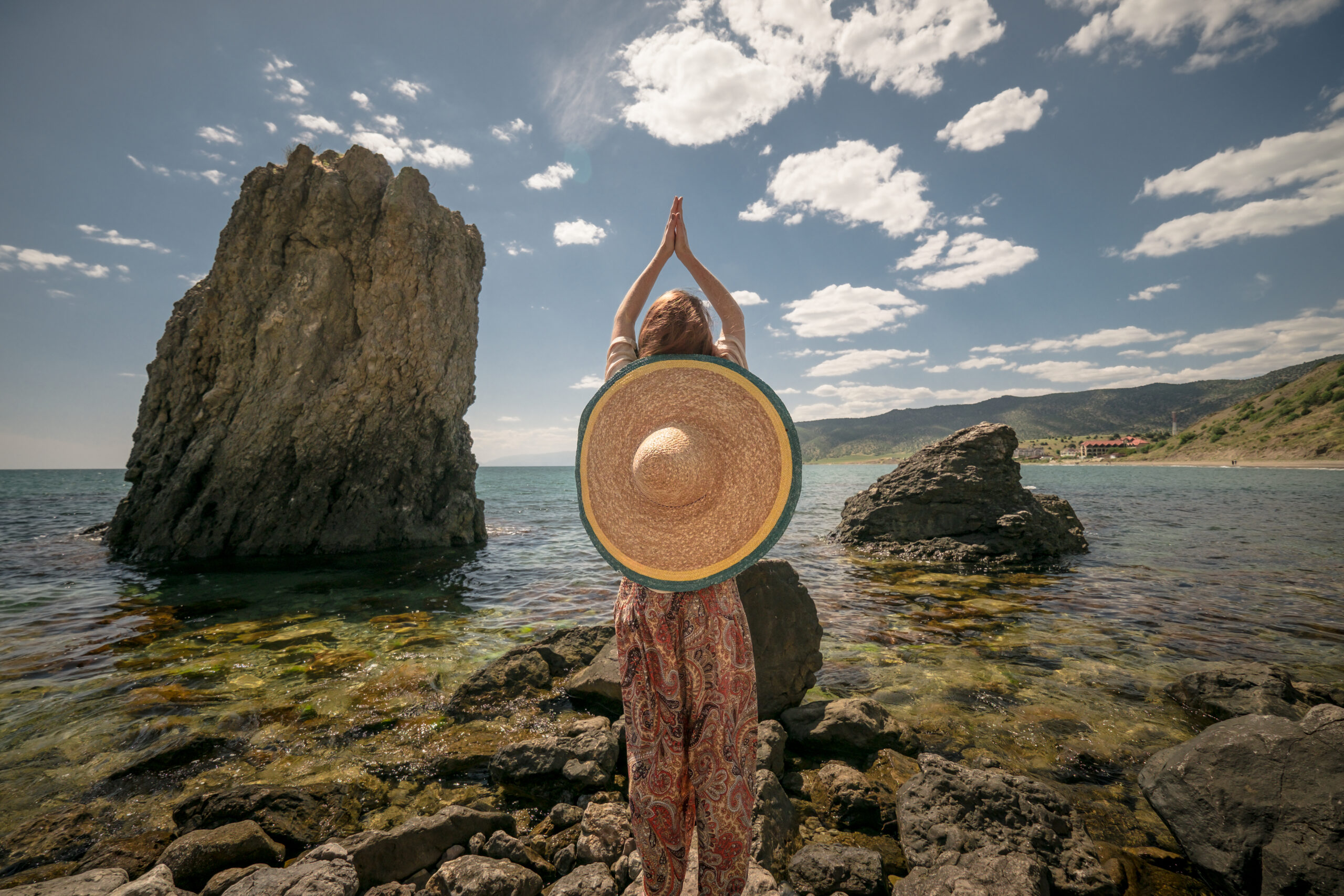 attractive young woman in ethnical costume on a field at sea